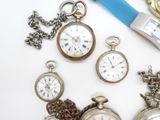 many different types of pocket watches on the table