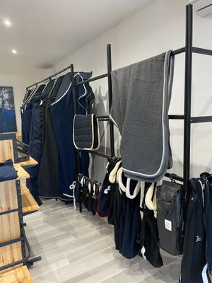 une photo d'un magasin de vêtements où des vêtements sont suspendus à un portemanteau