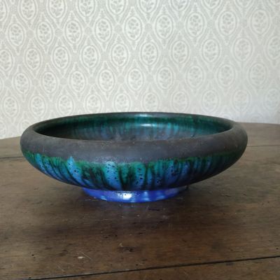 un bol bleu et vert posé sur une table en bois