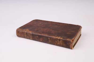 un vieux livre posé sur une surface blanche