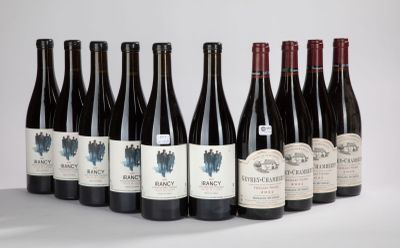 six bouteilles de vin sont alignées sur une surface blanche