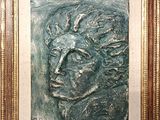 un gros plan sur un tableau représentant le visage d'un homme, dans un cadre doré