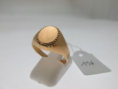 an image of a gold signet ring on a white surface with a price tag