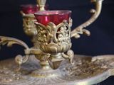 a gold plate with a red glass on it