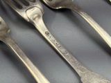 quatre fourchettes et deux cuillères posées sur une table