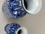 two blue and white vases sitting on a table