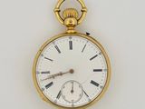 a gold pocket watch with roman numerals on the face