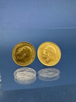 deux pièces d'or posées l'une à côté de l'autre sur une surface bleue
