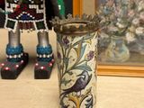 a small vase with a bird on it sitting on a table