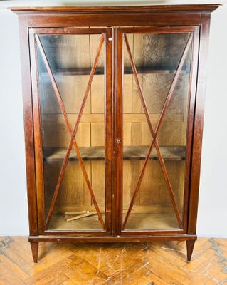 une photo d'une armoire en bois surmontée de portes vitrées