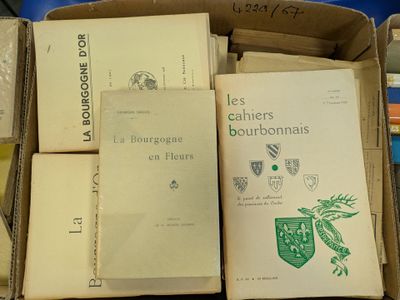 several books are stacked in a cardboard box on a table