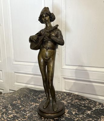statue en bronze représentant une femme tenant un panier posé sur une table en marbre