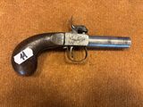 un vieux pistolet avec une étiquette, posé sur une surface brune