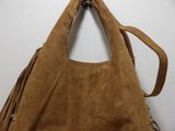 brown sued purse with fringes hanging on a wall