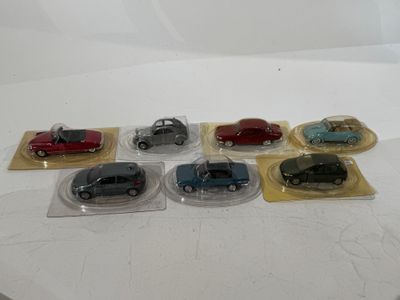 six small toy cars in plastic bags on a table