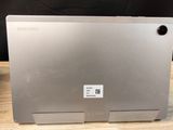 the back of a silver laptop computer sitting on top of a wooden table