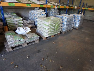 many bags of food sitting on pallets in a warehouse