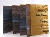 three pieces of wood with writing on them sitting on a white surface