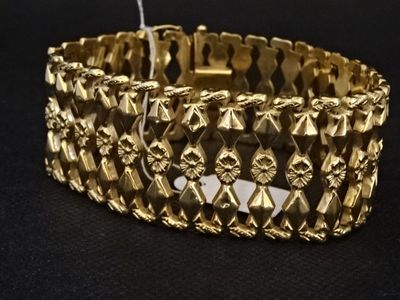 bracelet en or sur fond noir, avec une étiquette blanche au milieu