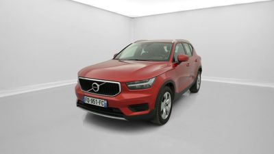 un SUV Volvo rouge garé dans une pièce blanche