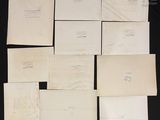 several envelopes of various sizes and shapes on a black surface