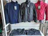 three jackets hanging on a rack in a clothing store