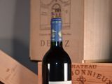 a bottle of wine sitting on a table next to a box of wine