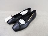 black leather ballet shoes with bows and tassels on the toes