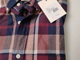 the shirt is red, blue, and white checkered with a tag on it