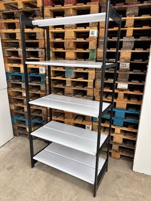 a close up of a shelf in a warehouse with pallets in the background