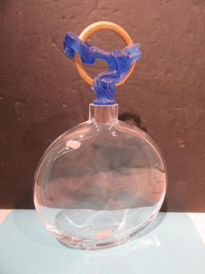 a glass vase with a blue bird on top of it