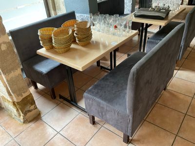 tables and chairs in a restaurant with empty wine glasses on the table