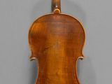 an old violin with a wooden back and bow on a gray background