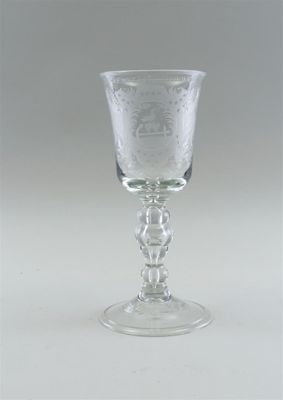 a glass with a design on it sitting on a table