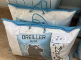 trois sacs d'oreillers Orieler posés par terre devant un radiateur
