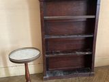 une petite table et une bibliothèque dans un coin de la pièce