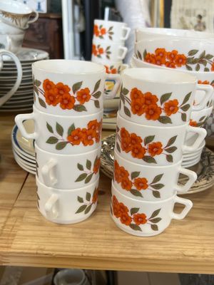 many cups and saucers sitting on a table