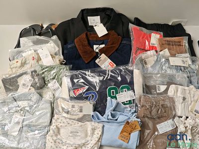 de nombreux types de vêtements différents, tous posés ensemble sur la table