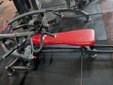 a red seat on a machine in a gym