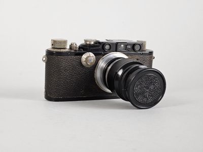 un appareil photo noir avec un objectif noir sur fond blanc