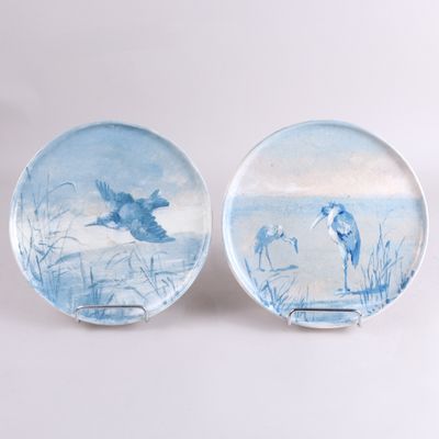 deux assiettes avec des oiseaux peints dessus, posées sur une table