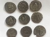 six ancient roman coins are displayed on a white surface