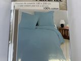 emballage d'un lit avec une couette bleue et un oreiller