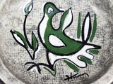 a plate with a bird painted on it sitting on a table