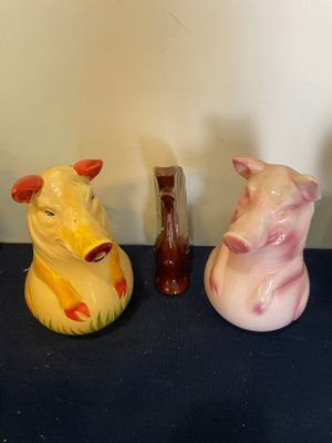 trois animaux en céramique posés sur une table à côté d'un vase