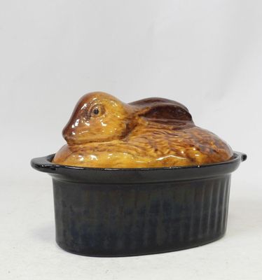 a ceramic turtle sitting in a bowl on a white surface