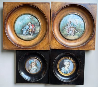 two framed pictures of a couple of people sitting on top of a table