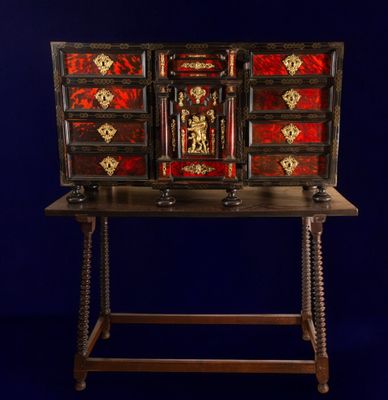 an old wooden desk with a red and gold design on it