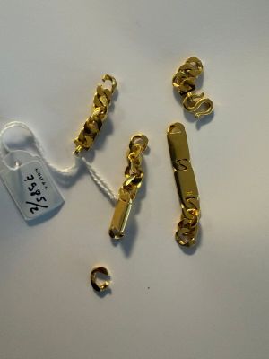 some gold chains and a tag on a white surface