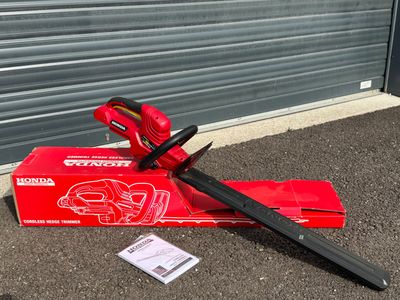 une boîte rouge avec une poignée noire et une paire de ciseaux par terre